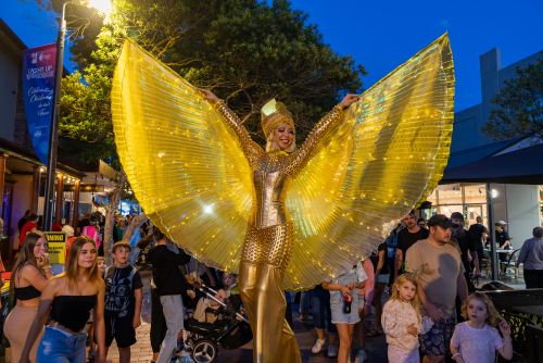 Picture of a stilt walker in glittery gold sequins