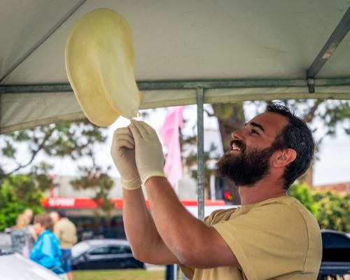 Picture of a chef tossing a pizza base