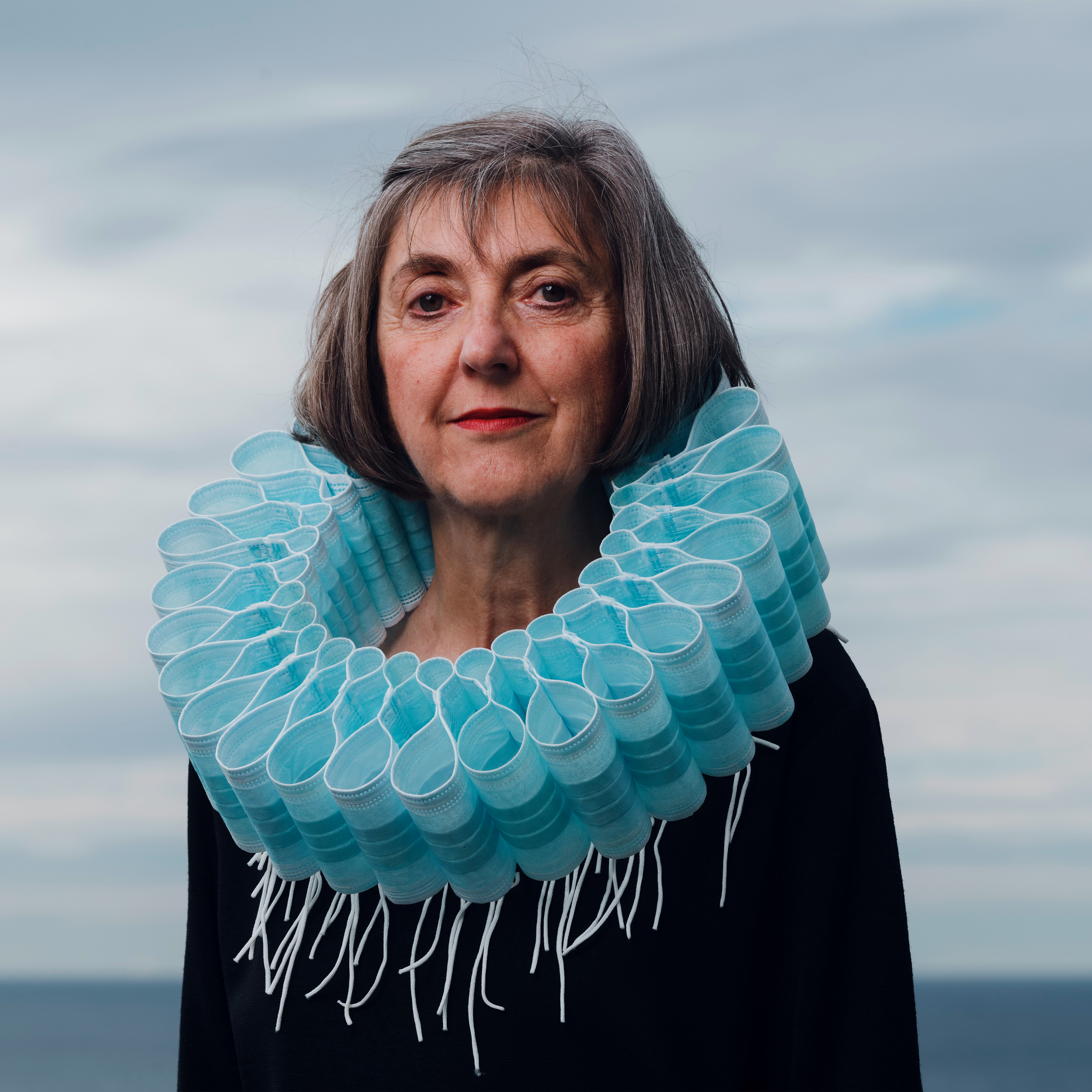 Artist Ruth Downes wearing one of her works - a collar made of masks