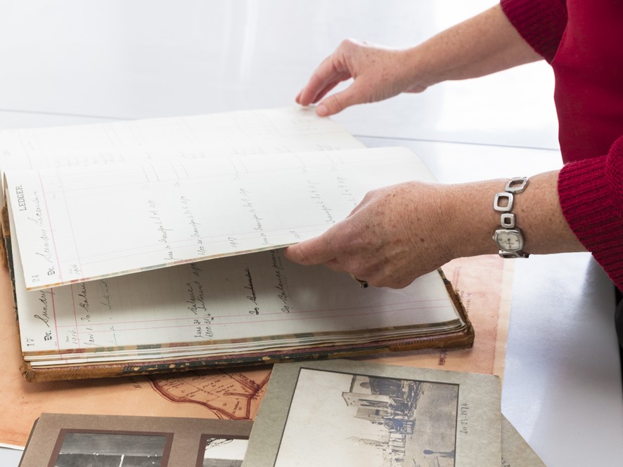 Picture of a woman inspecting a historical ledger